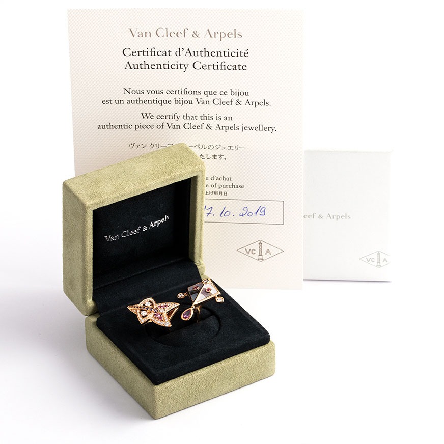 Shot of the Van Cleef and Arpels Cerfs-Volants ring in the Box with certificates. The ring looks like two kite set with diamonds and sapphires in rose gold.