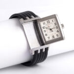 Side view of Jaeger LeCoultre Reverso Gran'Sport Automatic Linto Steel Wristwatch. Displaying a white face dial, this adaptable timepiece has a date window at the 6 o'clock position and uses Arabic numerals as hour markers. Rubber bracelet.