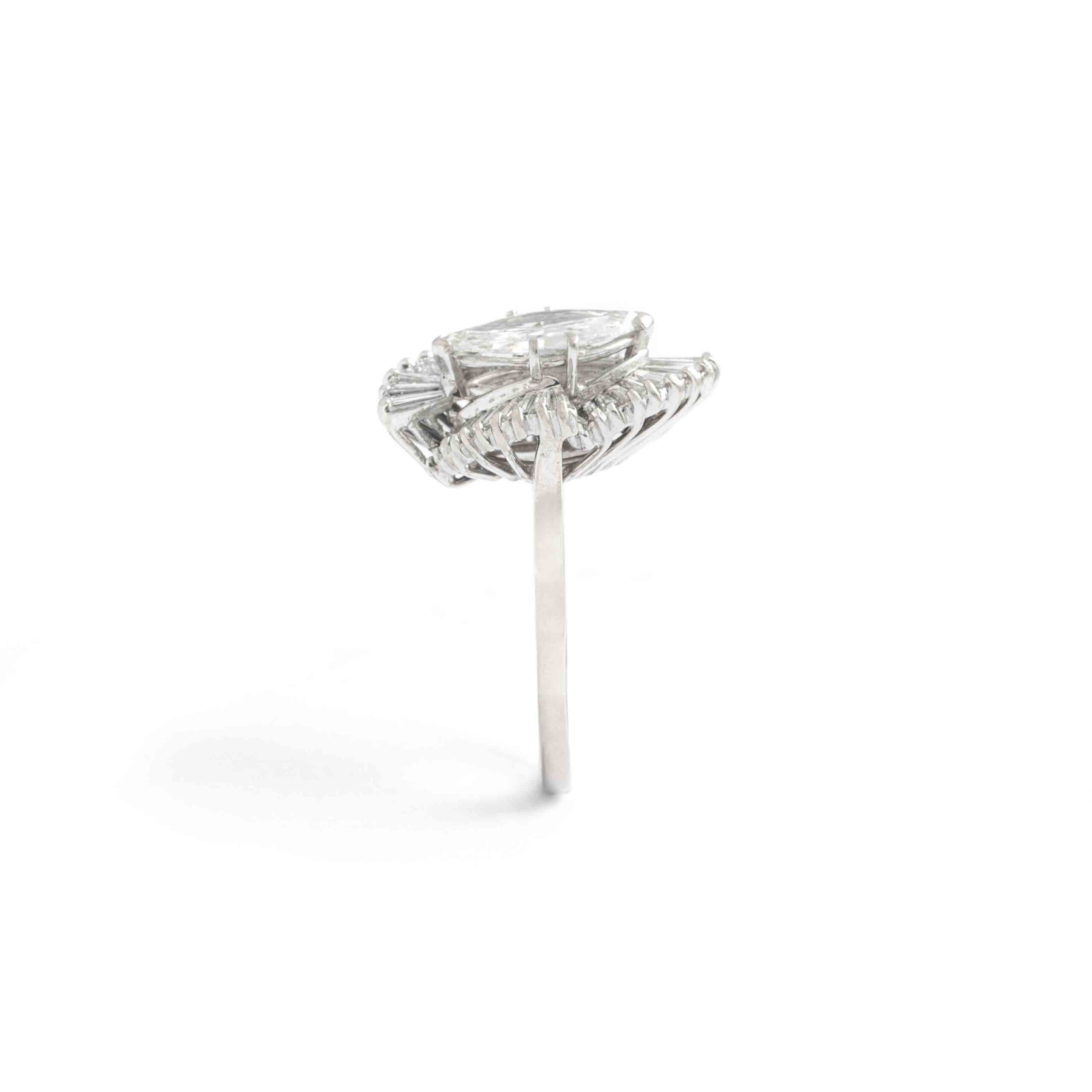 1.38 Carat Marquise Diamond White Gold 14K Ring. The central marquise Diamond weights 1.38 carat, F color and Si2 clarity, No fluorescence surrounded by baguette cut diamond. Circa 1950.