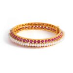 Indian Bangle set by baroque pearls and round cut rubies on yellow gold. Circumference: approximately 19.00 centimeters. Weight: 39.00 grams.