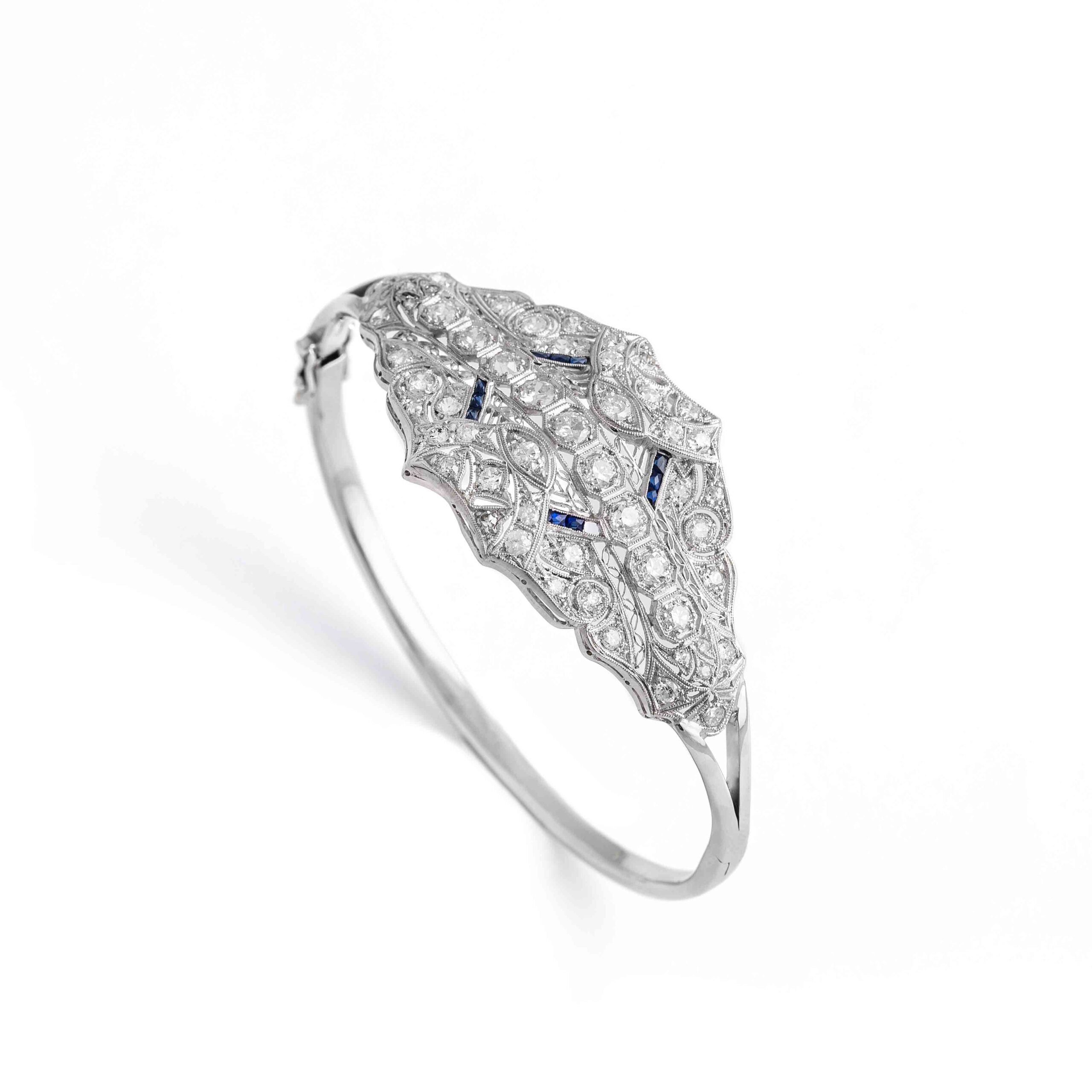 Old mine cut Diamond and calibrated Sapphire on Platinum and 14K White Gold Bangle. One sapphire missing. Top part dimensions: 5.50 centimeters x 3.00 centimeters. Wrist size: 18.00 centimeters.